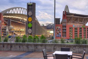 A clock tower is in the background of a stadium.